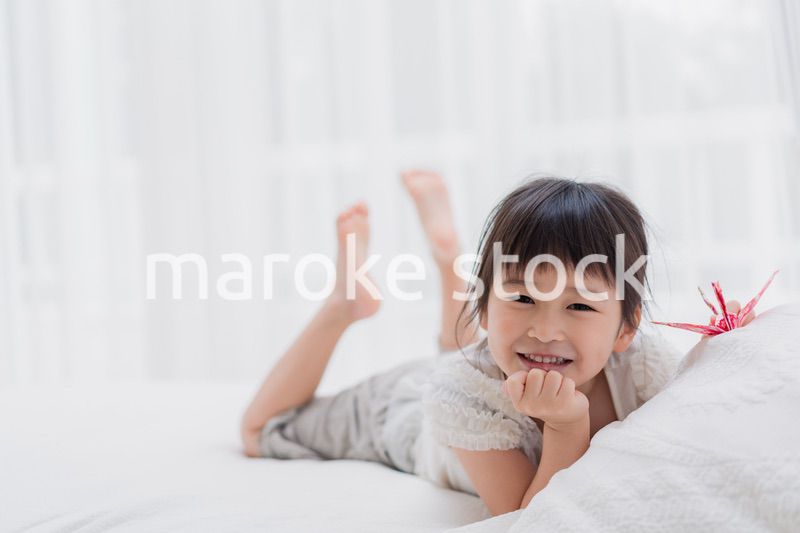 ベッドに寝転がる小さな女の子