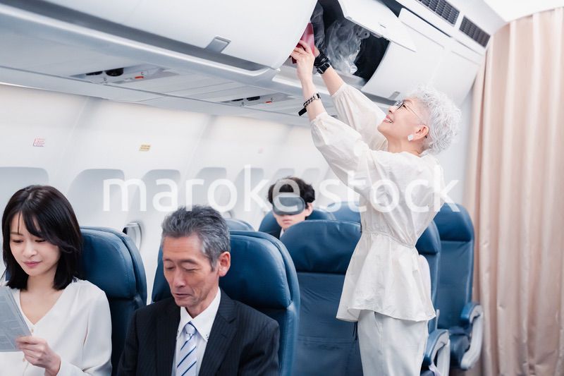 機内持ち込みの荷物を取り出す乗客