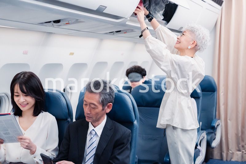 機内持ち込みの荷物を取り出す乗客