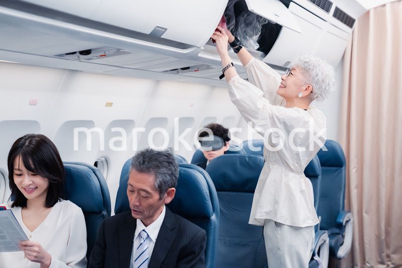 機内持ち込みの荷物を取り出す乗客