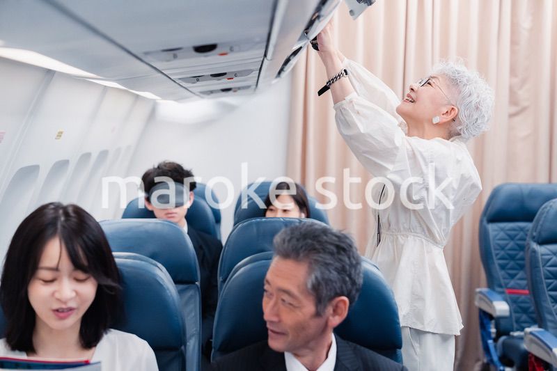 機内持ち込みの荷物を取り出す乗客