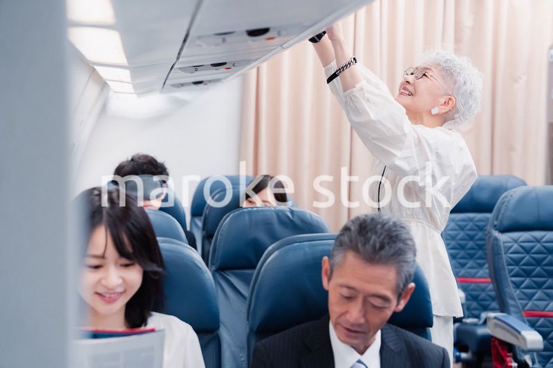 機内持ち込みの荷物を取り出す乗客