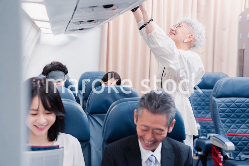 機内持ち込みの荷物を取り出す乗客