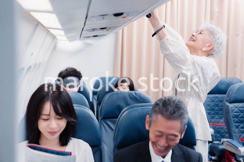 機内持ち込みの荷物を取り出す乗客