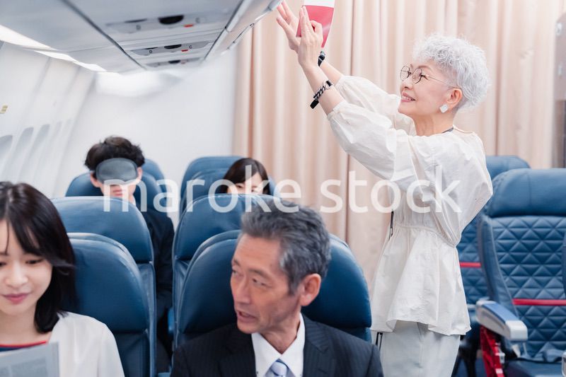 機内持ち込みの荷物を取り出す乗客