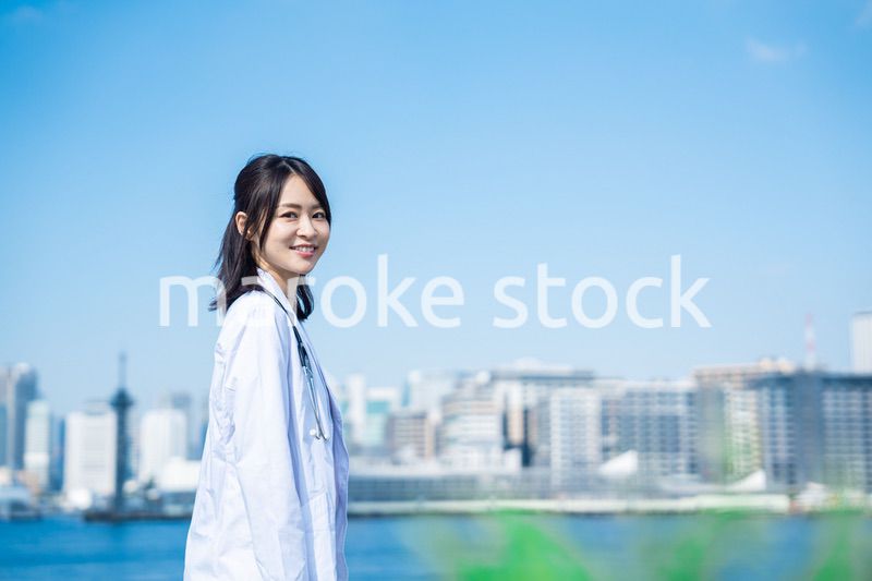 笑顔で外を歩く女性のドクター