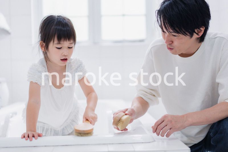 パパと一緒にお風呂掃除をする小さな女の子