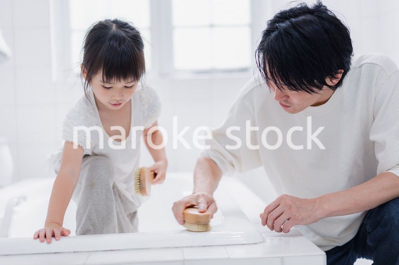 パパと一緒にお風呂掃除をする小さな女の子