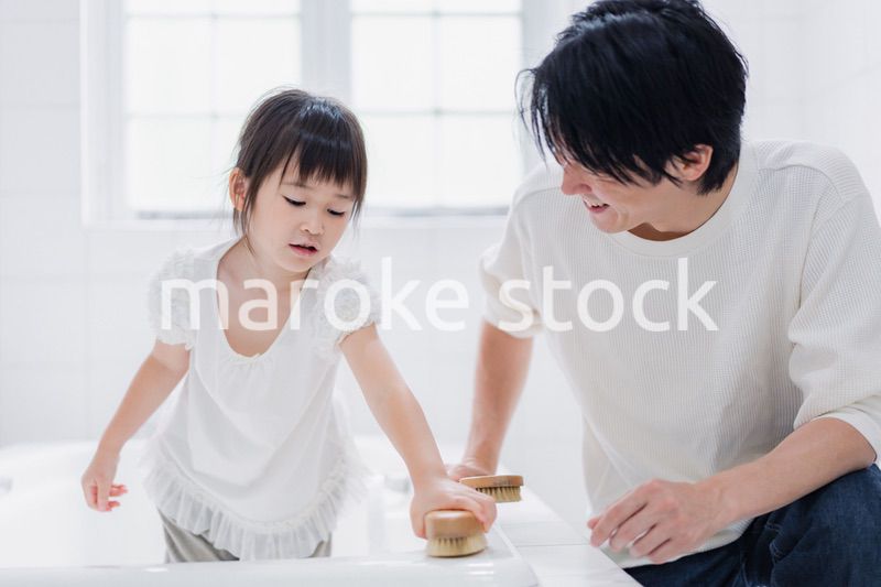 パパと一緒にお風呂掃除をする小さな女の子