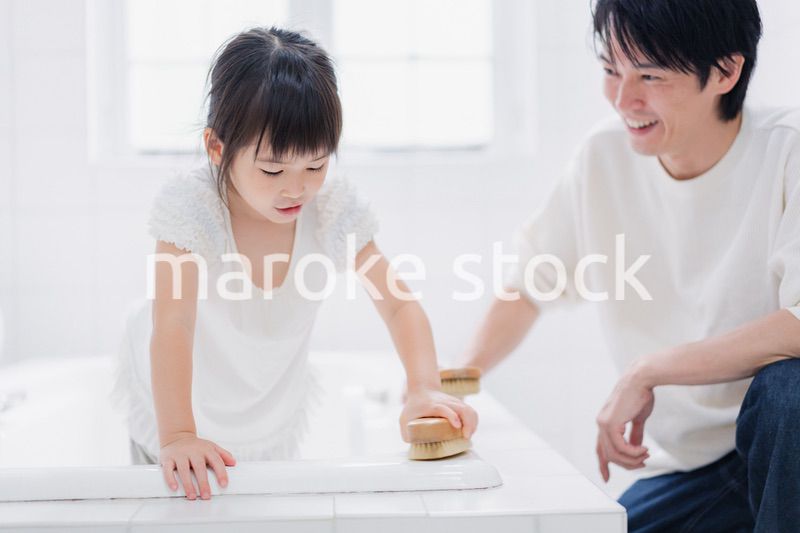 パパと一緒にお風呂掃除をする小さな女の子