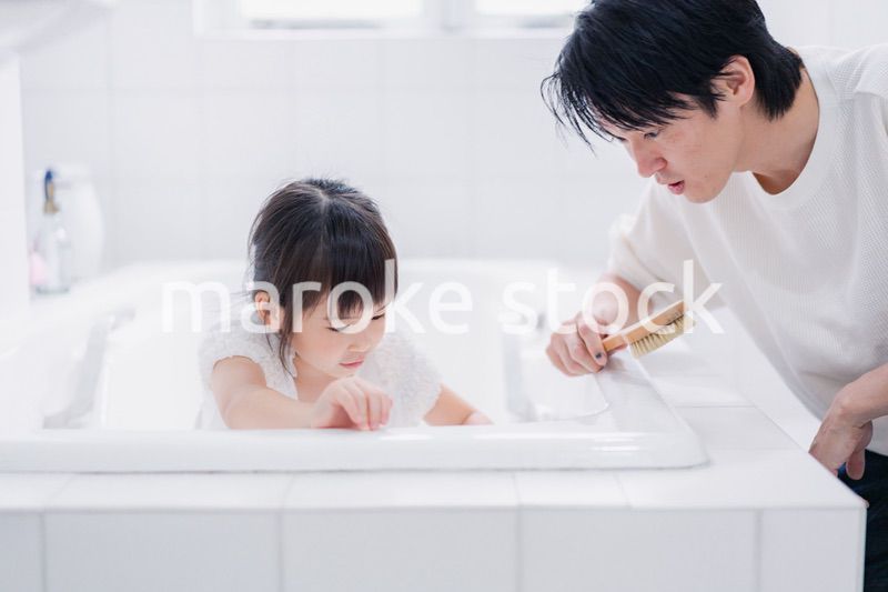 パパと一緒にお風呂掃除をする小さな女の子