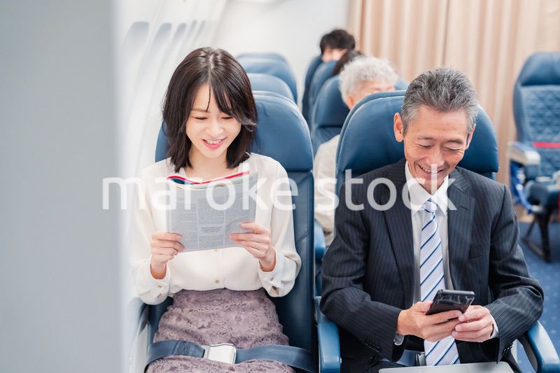 飛行機の機内で過ごす乗客