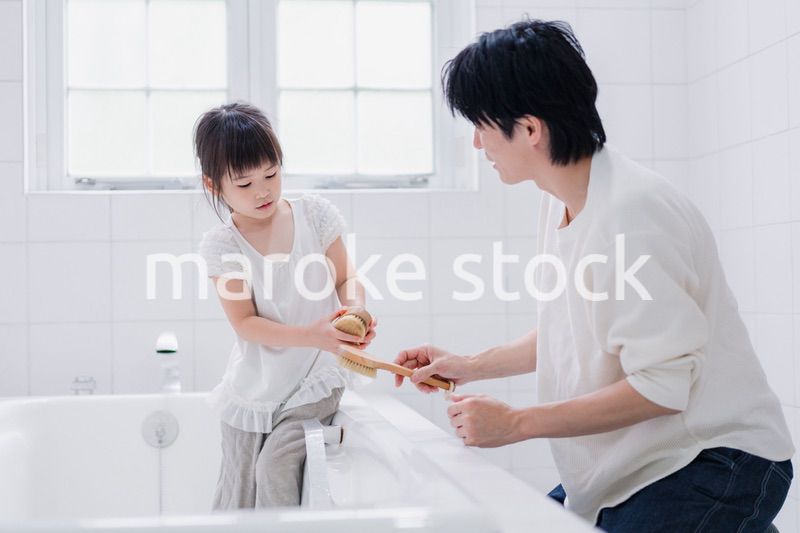 パパと一緒にお風呂掃除をする小さな女の子