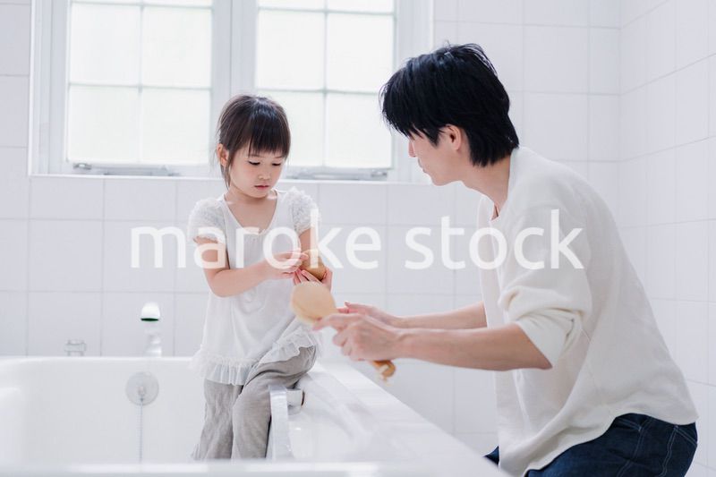 パパと一緒にお風呂掃除をする小さな女の子