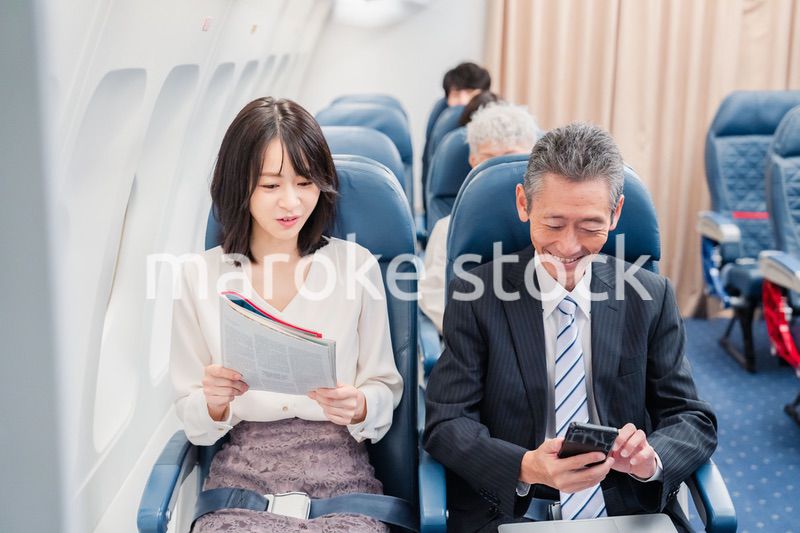 飛行機の機内で過ごす乗客