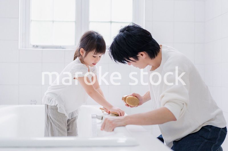 パパと一緒にお風呂掃除をする小さな女の子