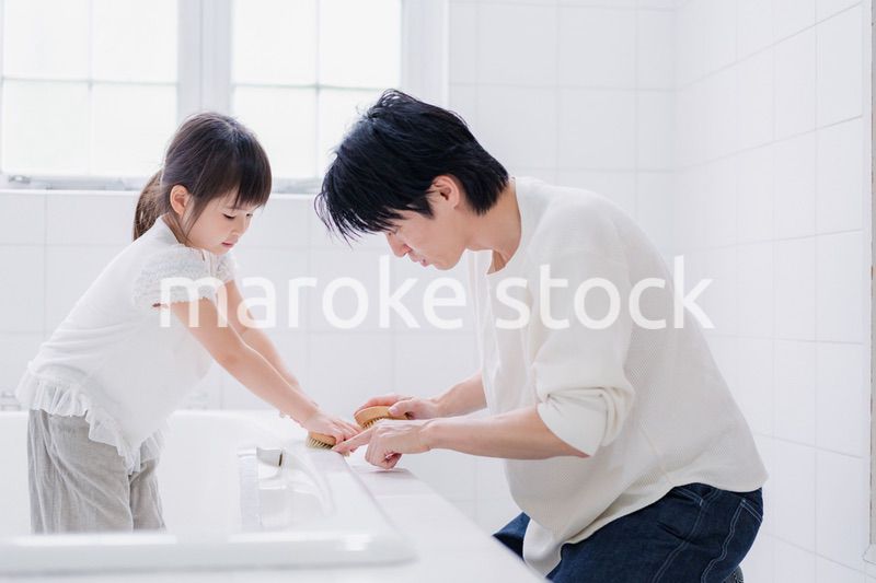 パパと一緒にお風呂掃除をする小さな女の子