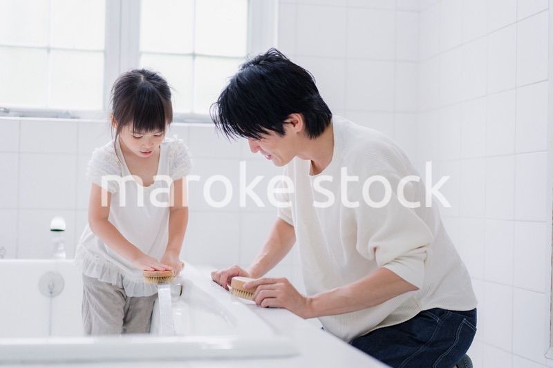パパと一緒にお風呂掃除をする小さな女の子