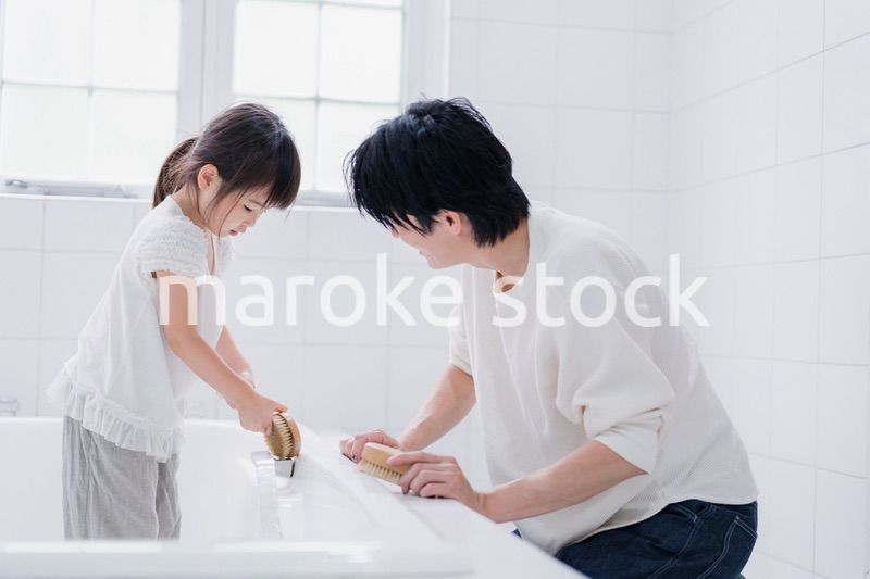 パパと一緒にお風呂掃除をする小さな女の子