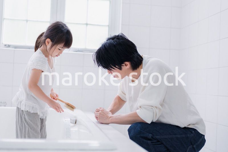 パパと一緒にお風呂掃除をする小さな女の子