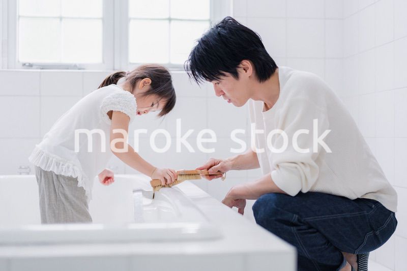 パパと一緒にお風呂掃除をする小さな女の子