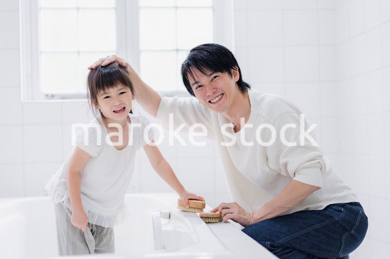 パパと一緒にお風呂掃除をする小さな女の子