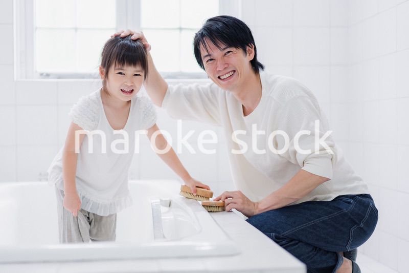 パパと一緒にお風呂掃除をする小さな女の子