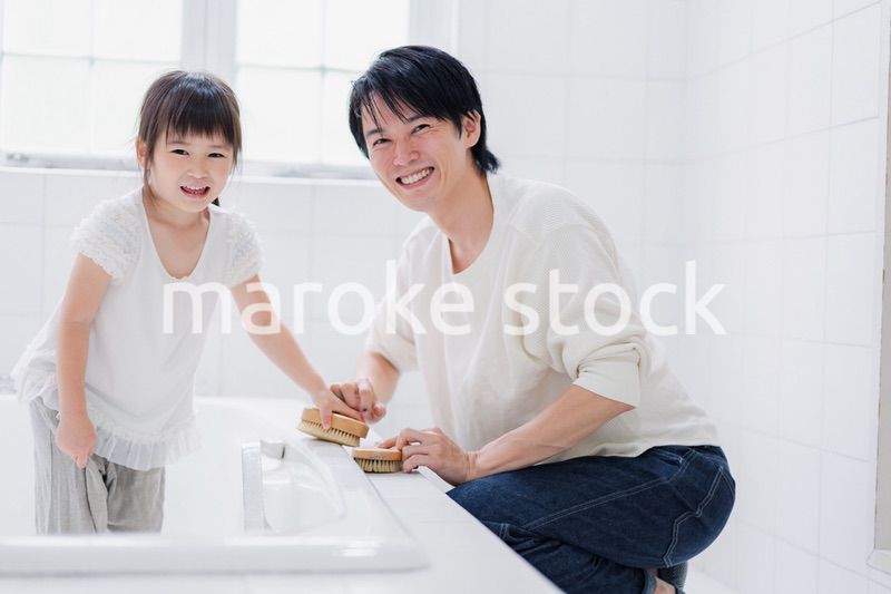パパと一緒にお風呂掃除をする小さな女の子