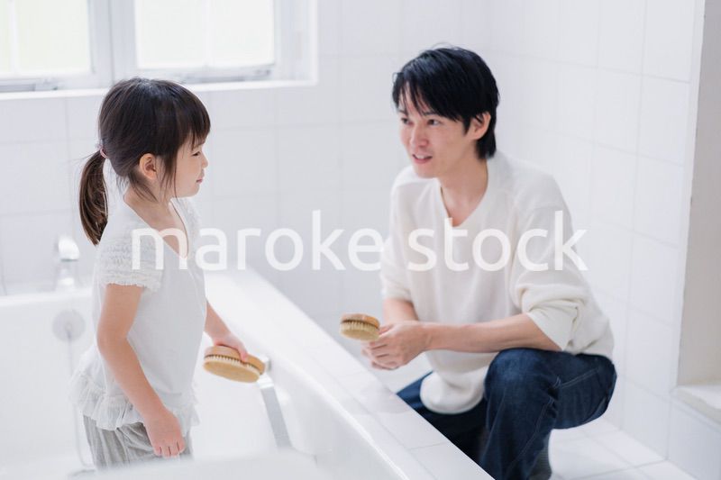 パパと一緒にお風呂掃除をする小さな女の子