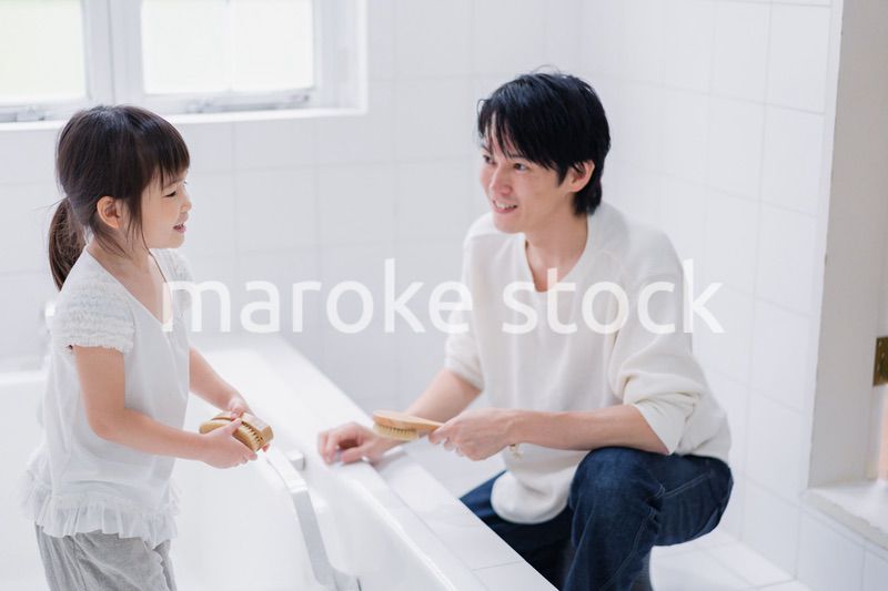 パパと一緒にお風呂掃除をする小さな女の子