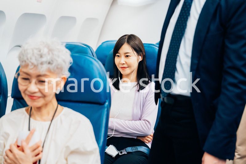 機内でイヤフォンを使う女性