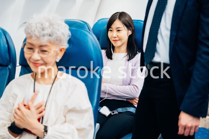 機内でイヤフォンを使う女性