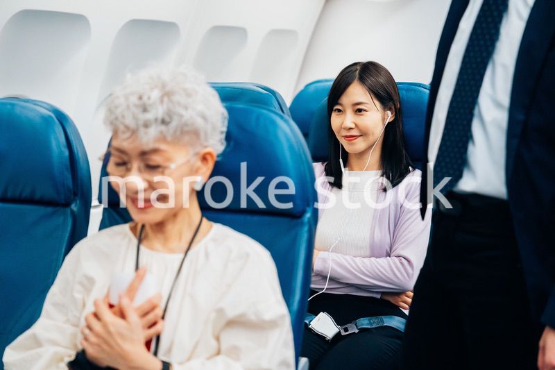 機内でイヤフォンを使う女性