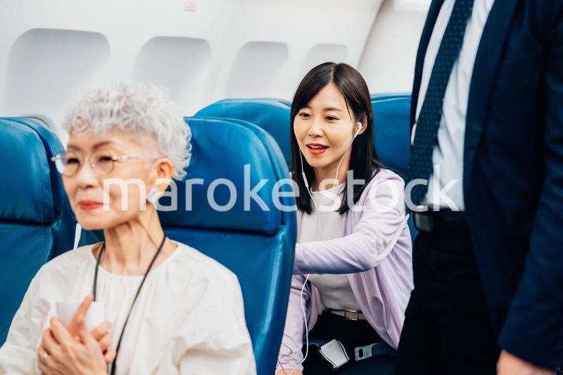 機内でイヤフォンを使う女性