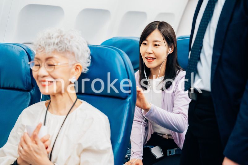 機内でイヤフォンを使う女性