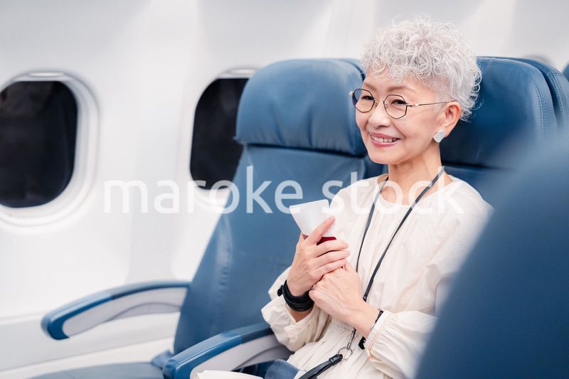 飛行機で旅行する高齢の女性