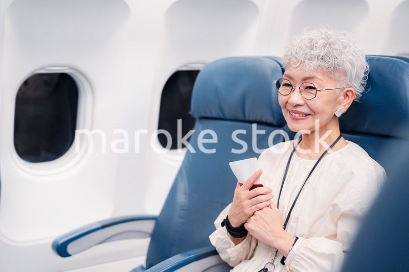 飛行機で旅行する高齢の女性