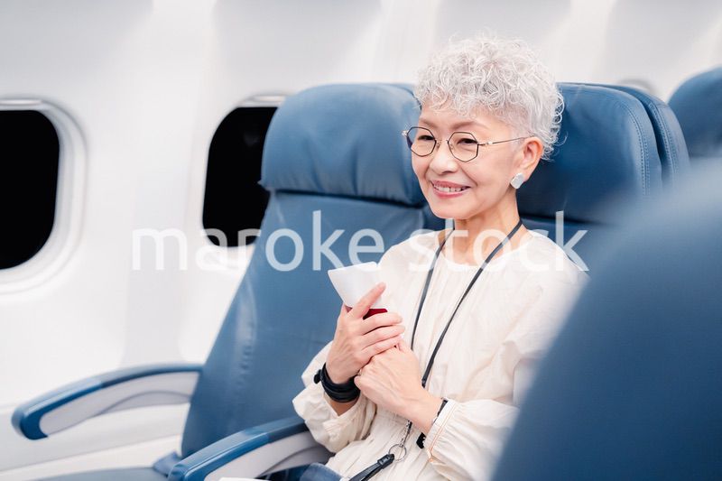 飛行機で旅行する高齢の女性