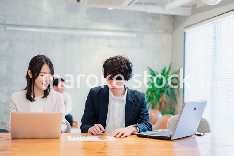 明るいオフィスに勤務をするビジネスパーソン