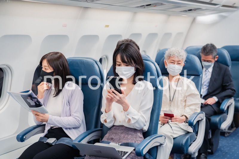 マスクをして飛行機に乗る乗客