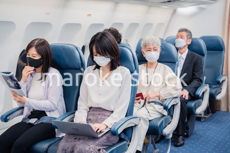 マスクをして飛行機に乗る乗客