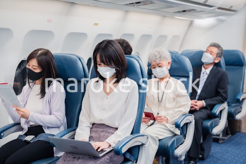 マスクをして飛行機に乗る乗客