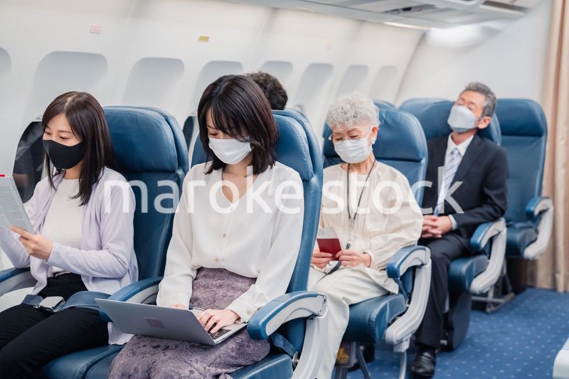 マスクをして飛行機に乗る乗客
