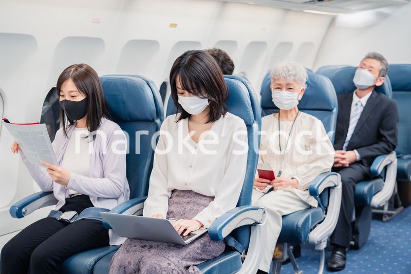 飛行機の機内で過ごす乗客