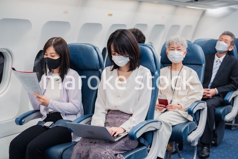 マスクをして飛行機に乗る乗客