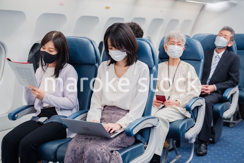 マスクをして飛行機に乗る乗客