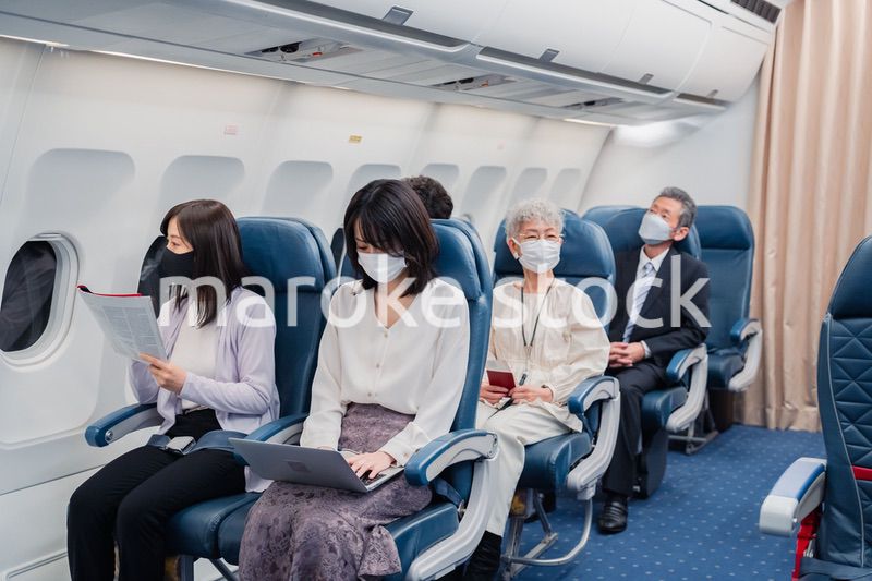 マスクをして飛行機に乗る乗客
