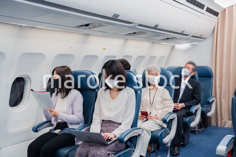 マスクをして飛行機に乗る乗客