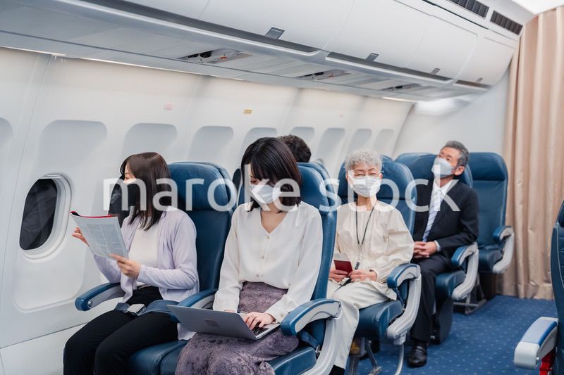 マスクをして飛行機に乗る乗客