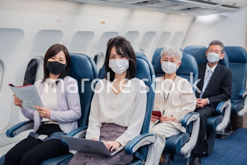 マスクをして飛行機に乗る乗客